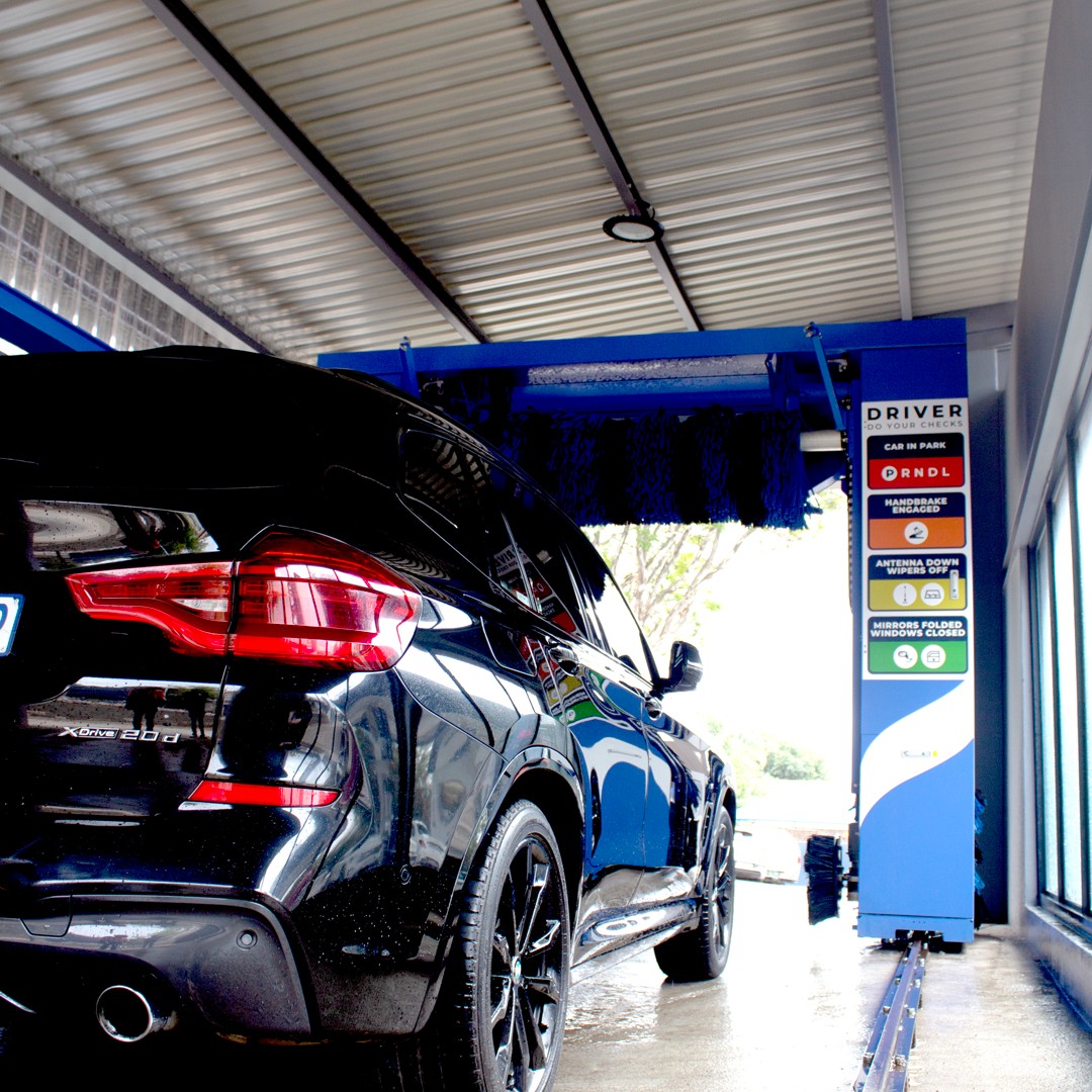 Black car in a wash bay at a partner carwash site