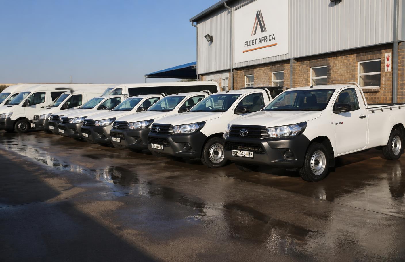Clean fleet of white bakkies and vans at a South African depot